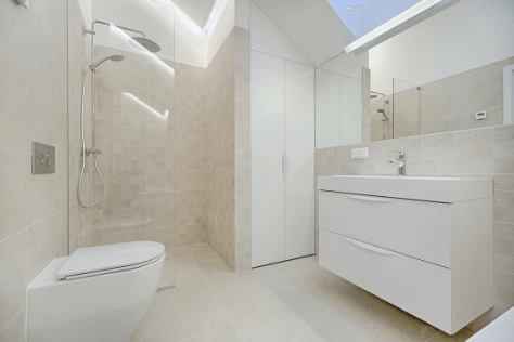 All-white bathroom with a tiled walk-in shower and floating vanity