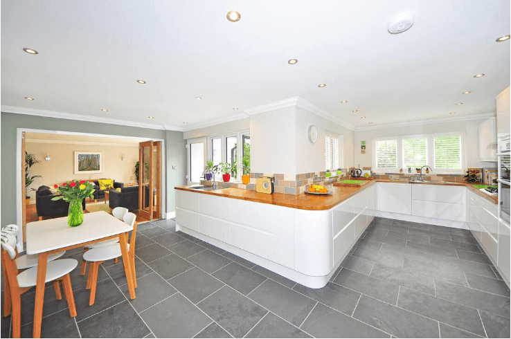Open-plan kitchen with dark grey floor tiles laid in a diagonal pattern