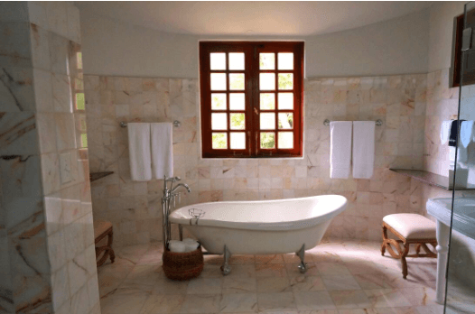 Renovated bathroom with a freestanding clawfoot bath and stone-look wall tiles